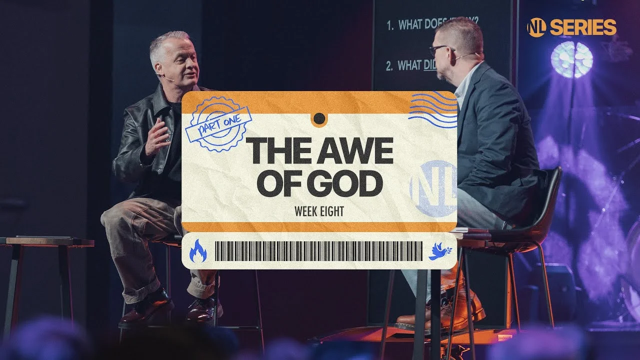 Two speakers seated on stage next to a screen titled "The Awe of God, Week Eight, Part One" from NL Series.