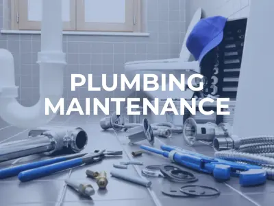 Construction worker performing maintenance on an open sewer line at a roadside construction site near a gas station.