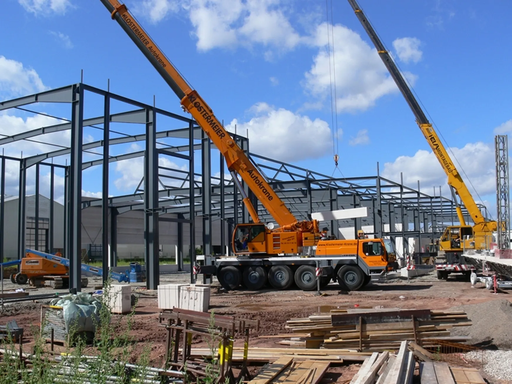 Bild einer Baustelle und 2 Kränen beim Errichten von Tragwerken für ein Bauprojekt