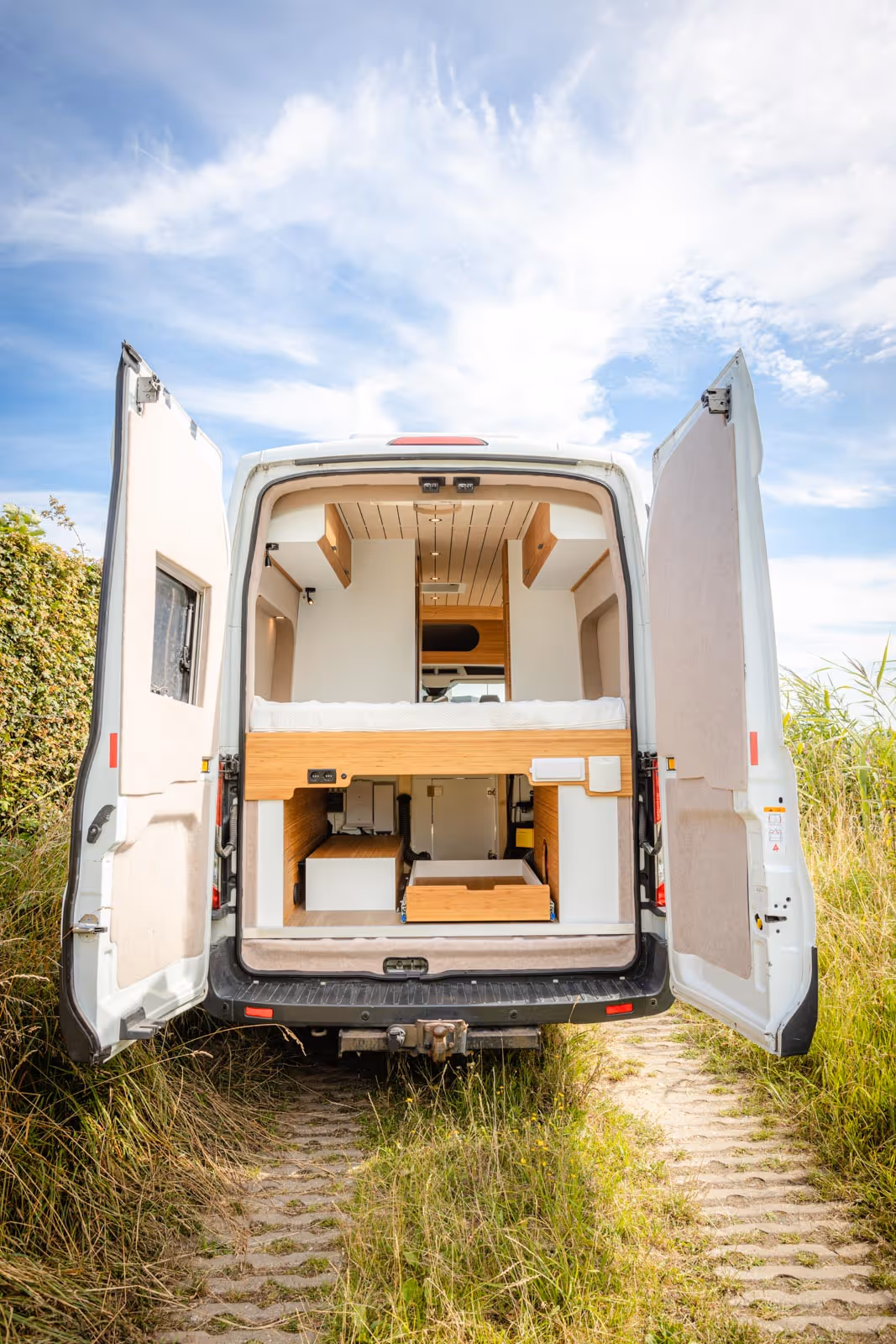 Ford transit met een camper interieur die gemaakt is door hop custom campers