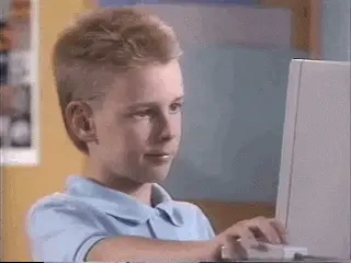 Kid giving thumbs up at computer.