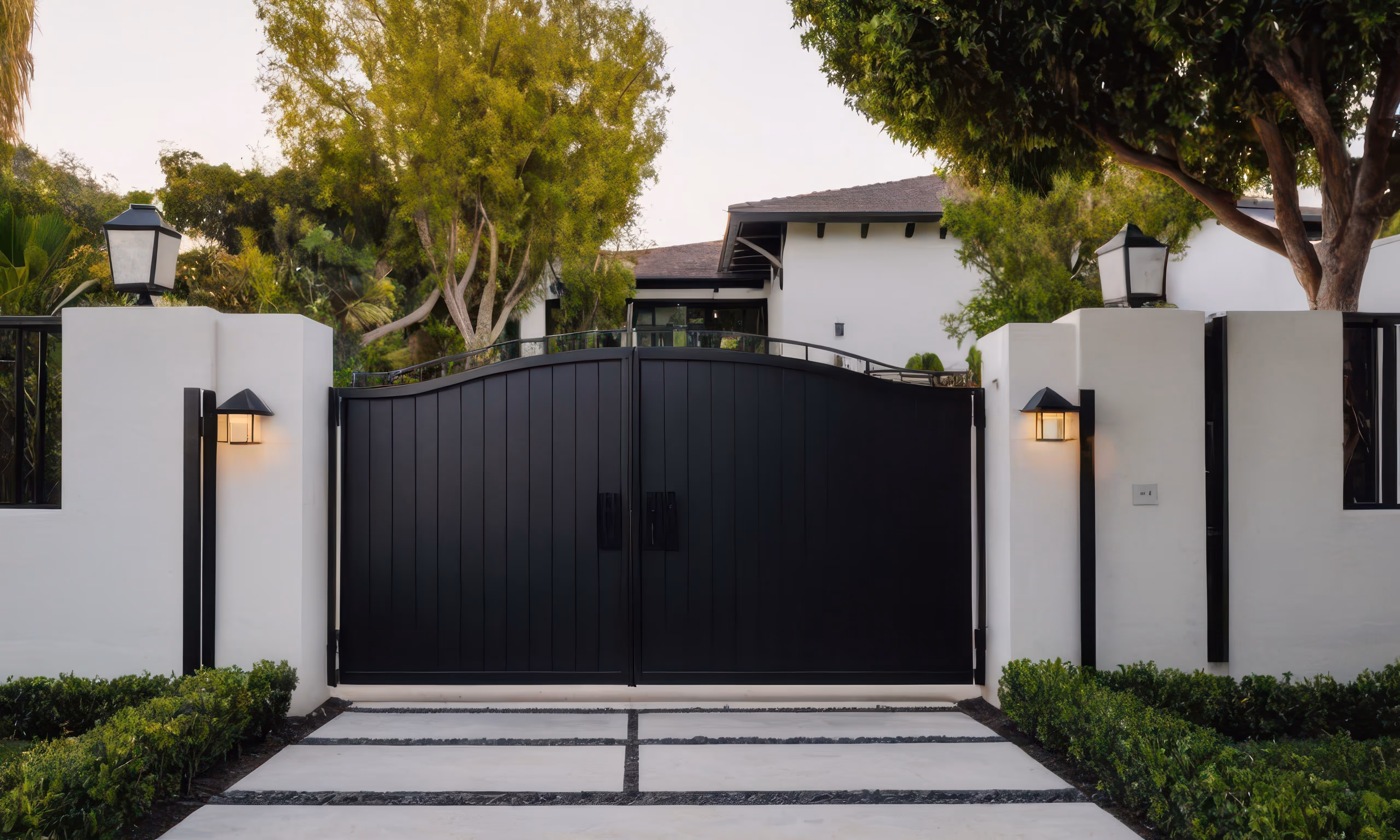 Custom black residential gate surrounded by white walls.
