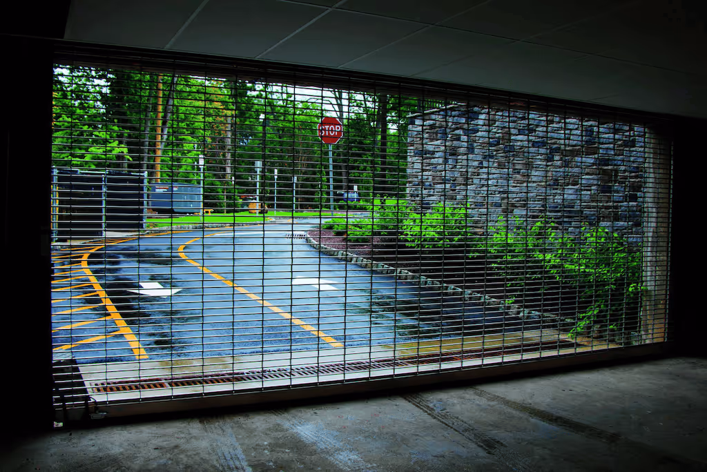 Inside of a garage looking out through a door grille