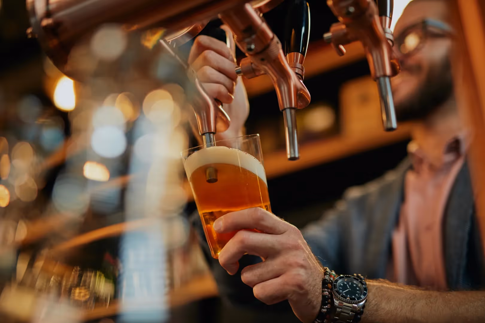 A bartender pouring a glass of beer from a tap, suggesting the local breweries and nightlife near Magnolia at Spring Hill in Spring Hill, Florida.
