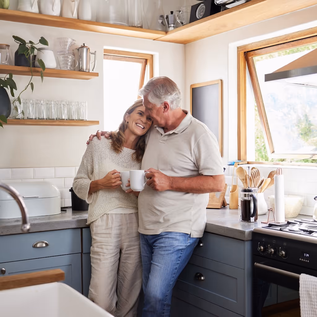 Couple embracing in a bright modern kitchen.