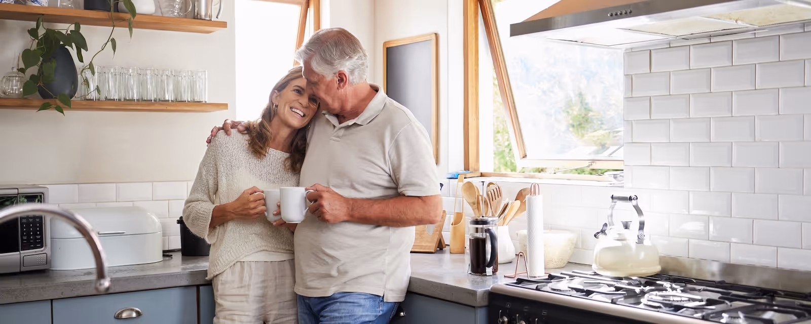 Couple embracing in a bright modern kitchen.