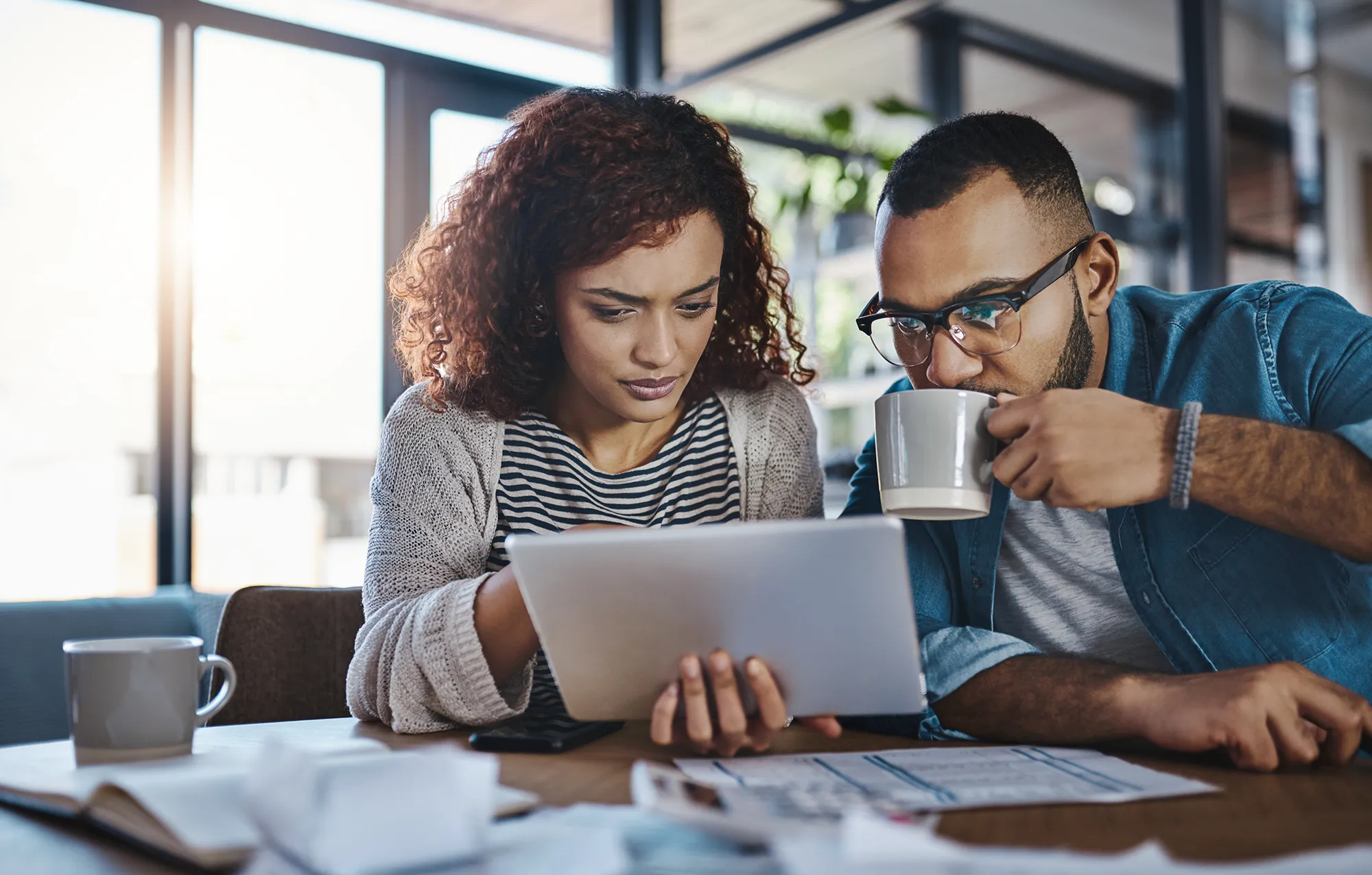 People looking at laptop with the current home interest rates on it.