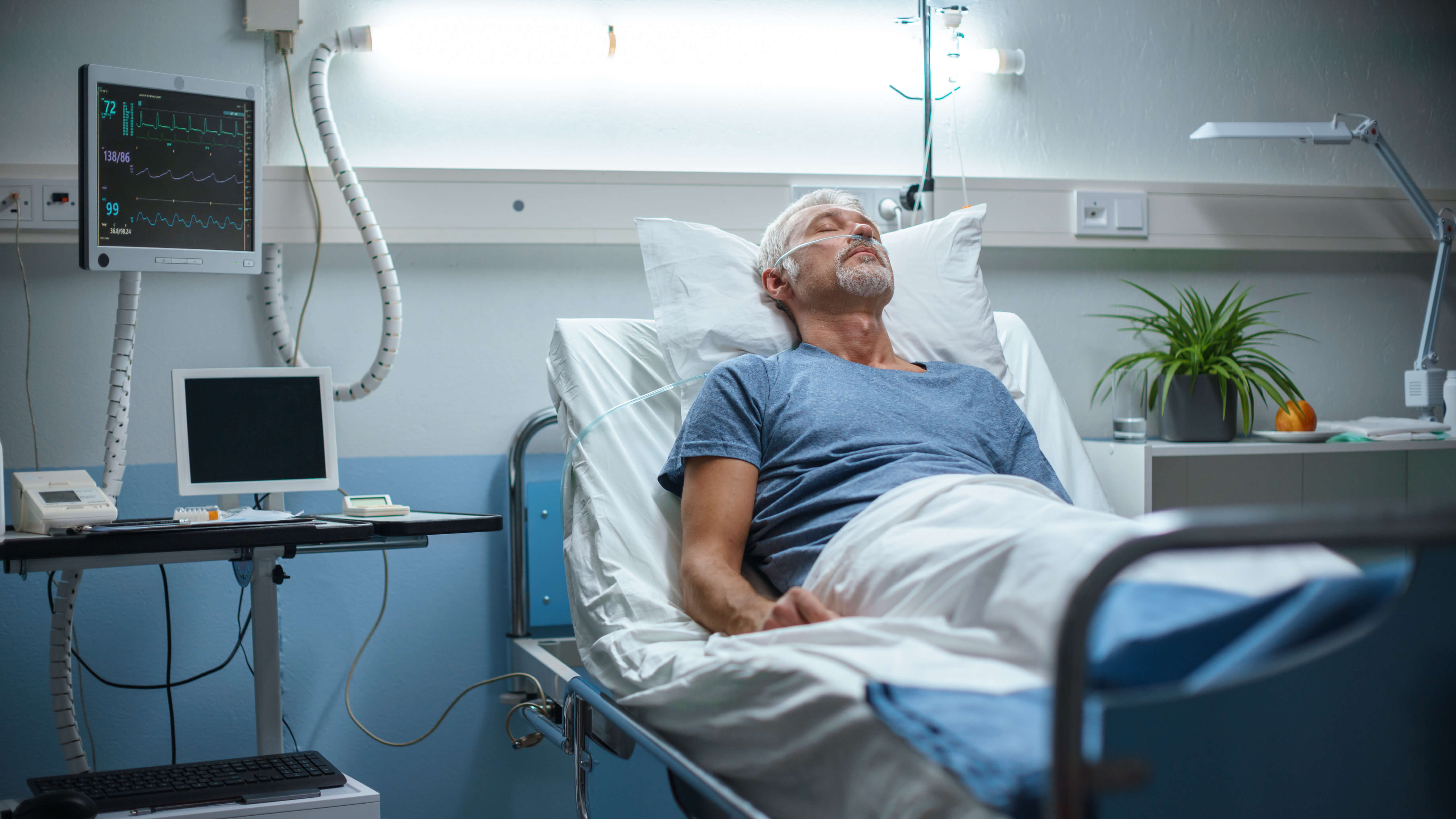 Older gentleman laying in hospital bed recovering,