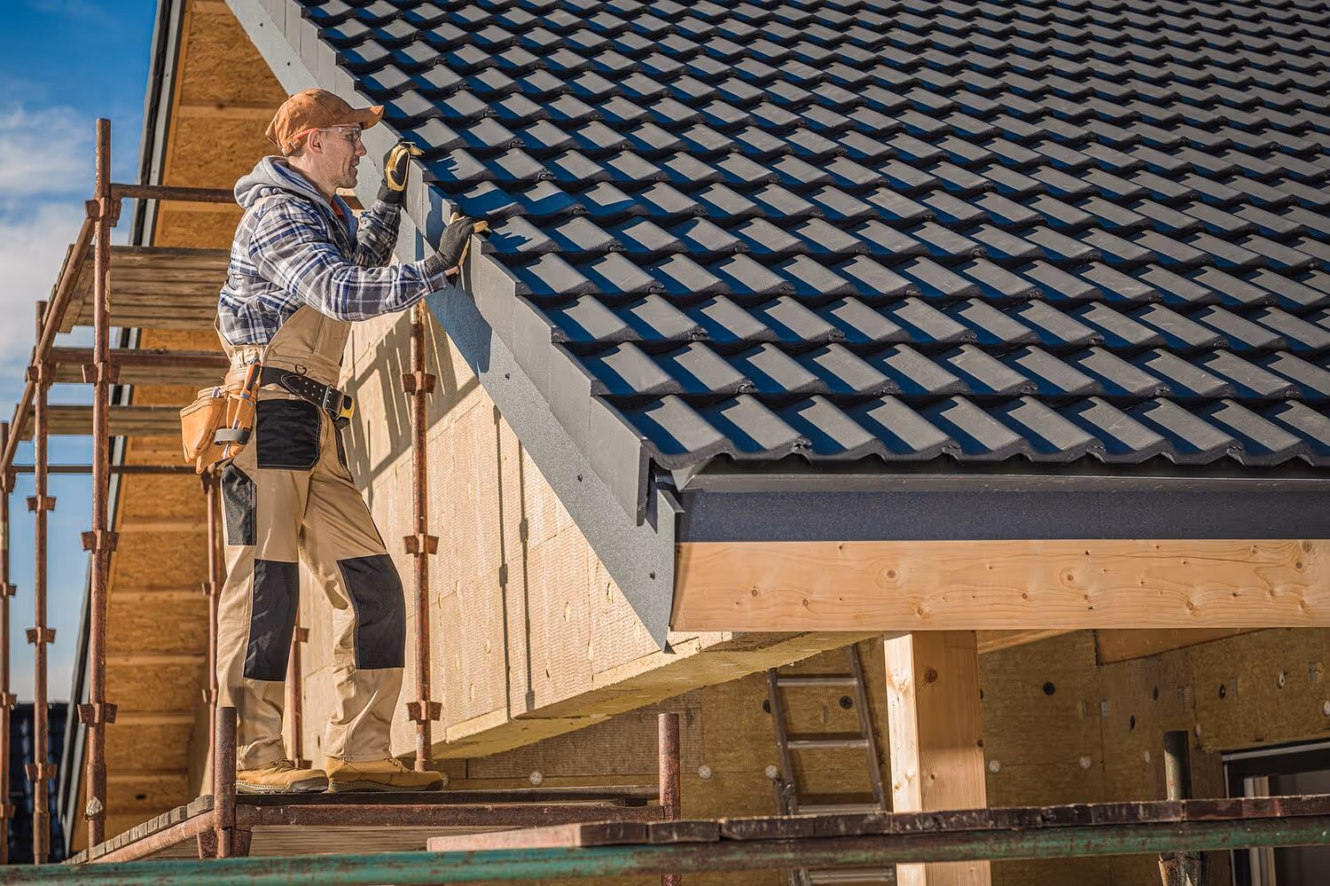 Professional roofer inspecting a finished black clay tile roof.