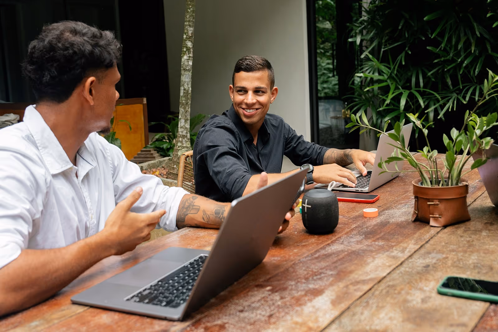 Two males in discussion on their computers taking an online training course for trade professionals.