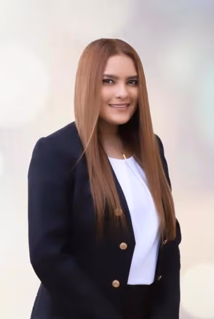 Portrait of a woman with long hair, wearing a black blazer and white blouse, smiling at the camera.
