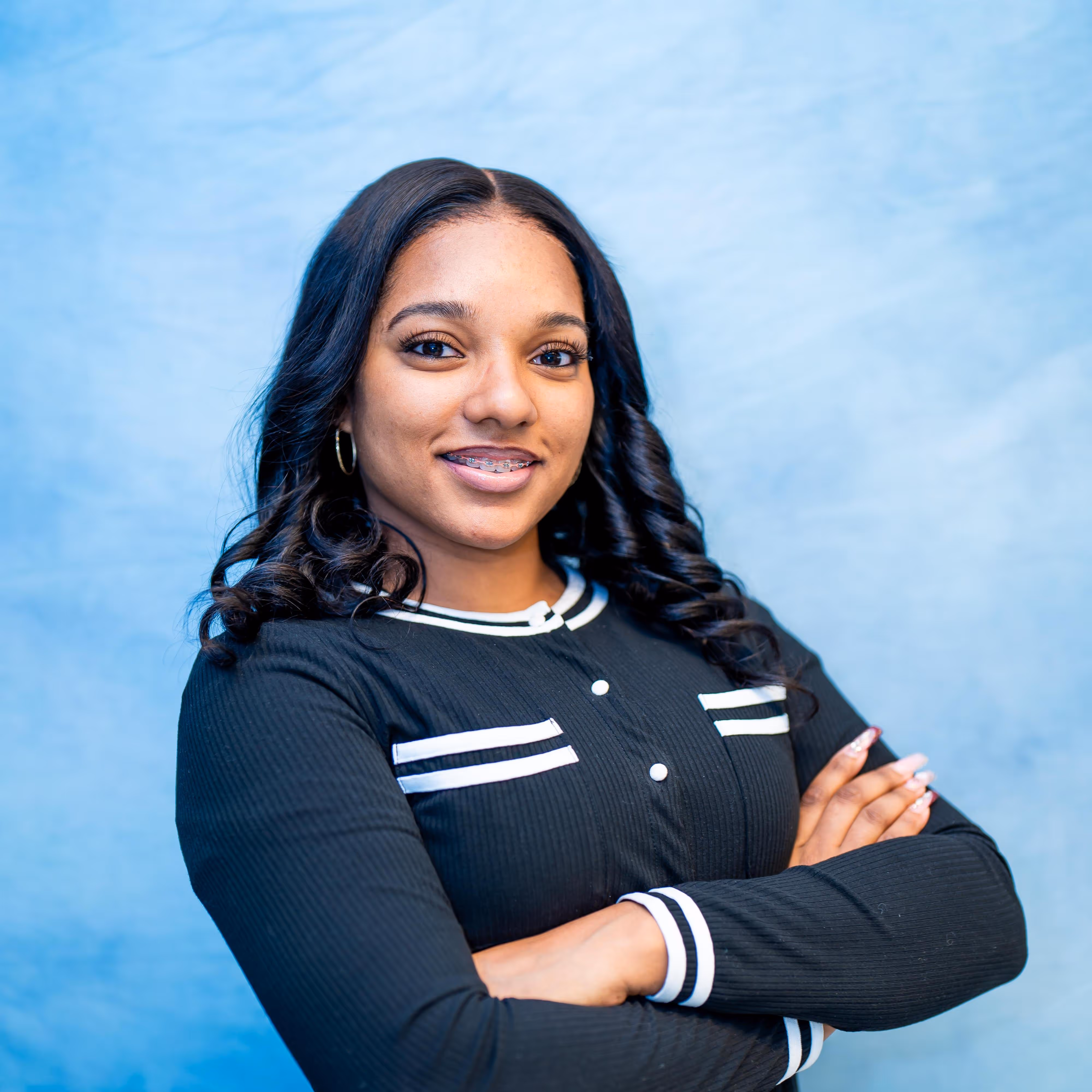 Professional headshot of a woman smiling in front of a blue background