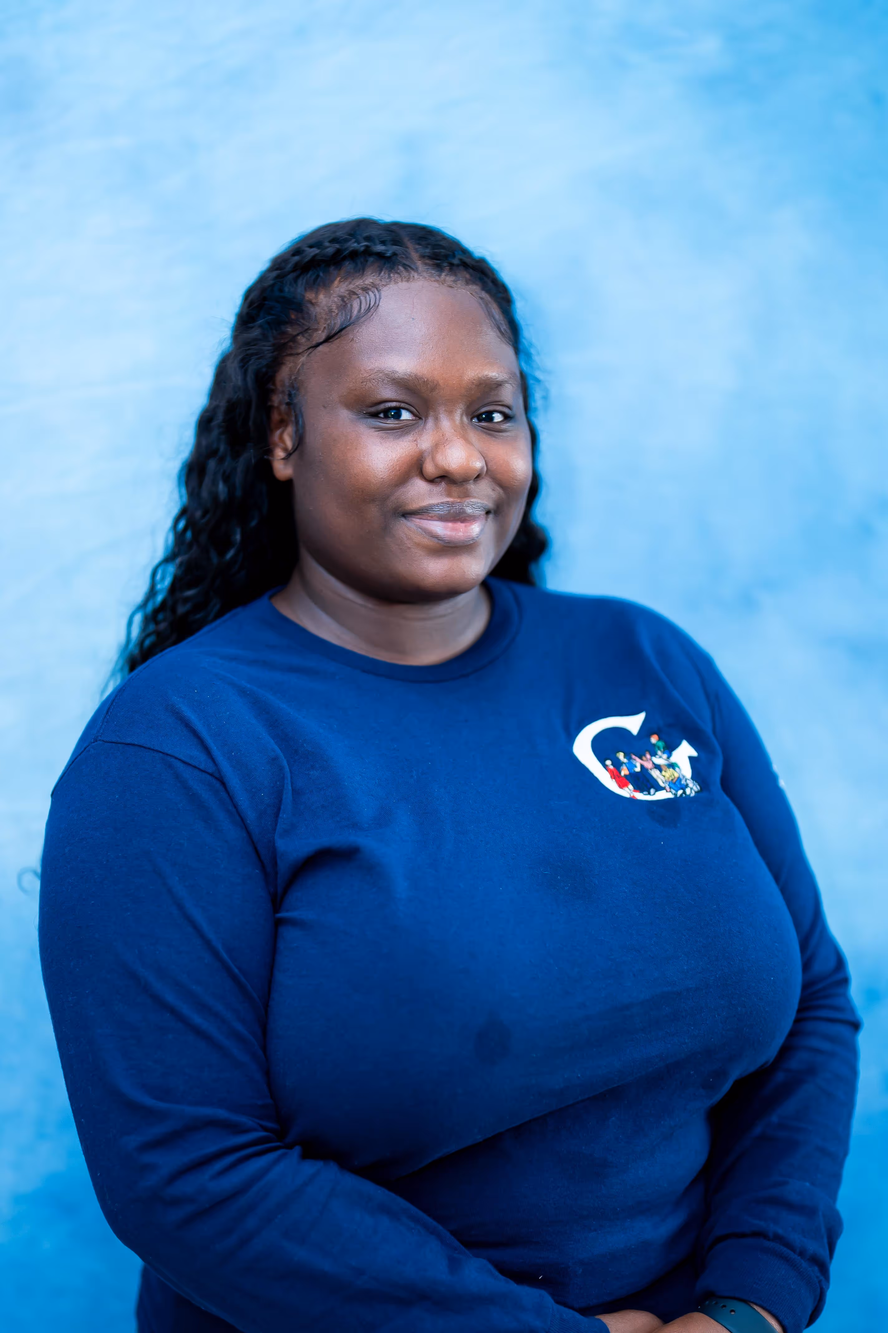 “Professional headshot of a woman smiling in front of a blue background
