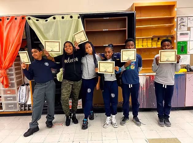 Students holding certificates and posing for a photo.