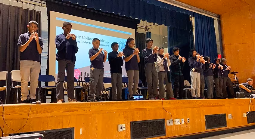 Students performing on stage in front of an audience.