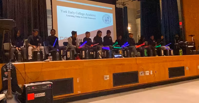 Students performing with instruments on stage.