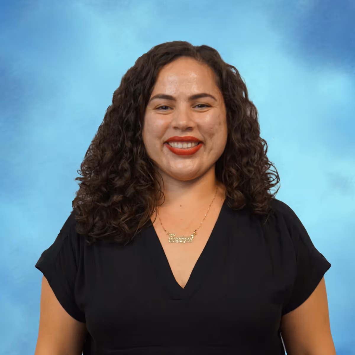 Professional headshot of a woman smiling in front of a blue background.