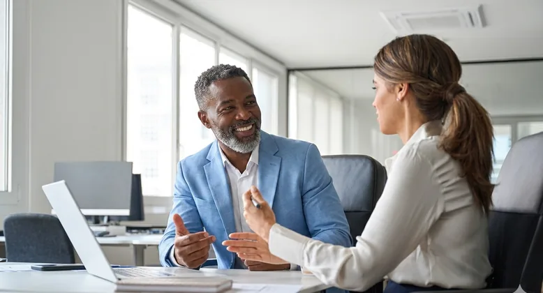 A manager giving a rep coaching feedback at her desk