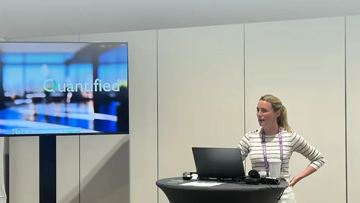 A Quantified teammate presents a session with the Quantified logo on screen