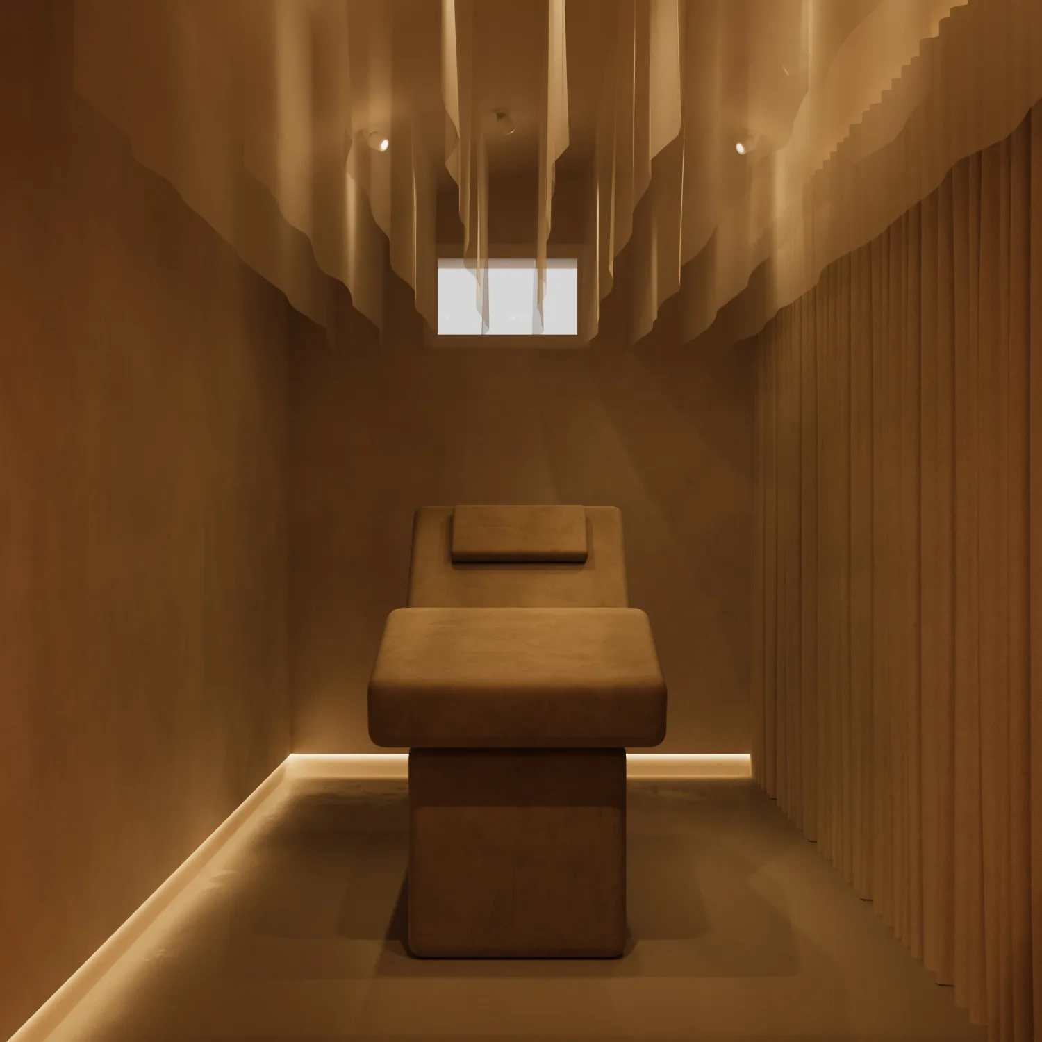 Minimalist spa room with a cushioned massage table centered under soft warm lighting and vertical hanging fabric strips.