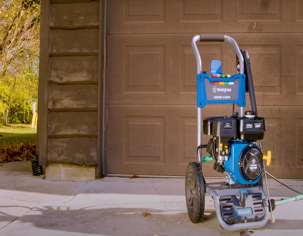 An image of a pressure washer gas powered in front of a garage.