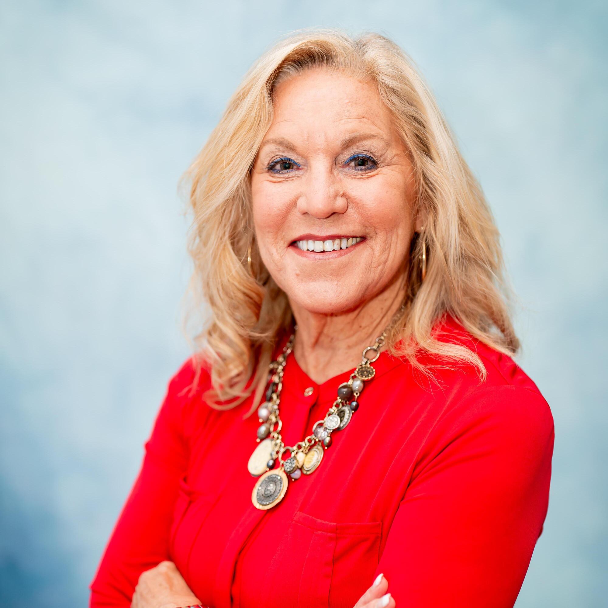 Professional headshot of staff member in red blouse