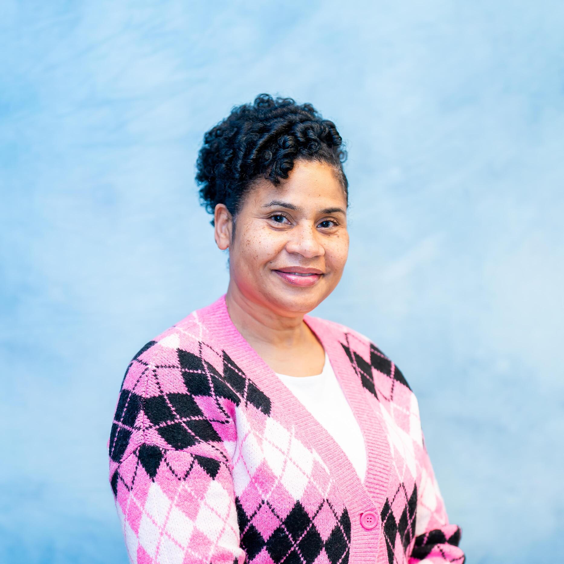 Staff member Kim Burnett in pink argyle cardigan