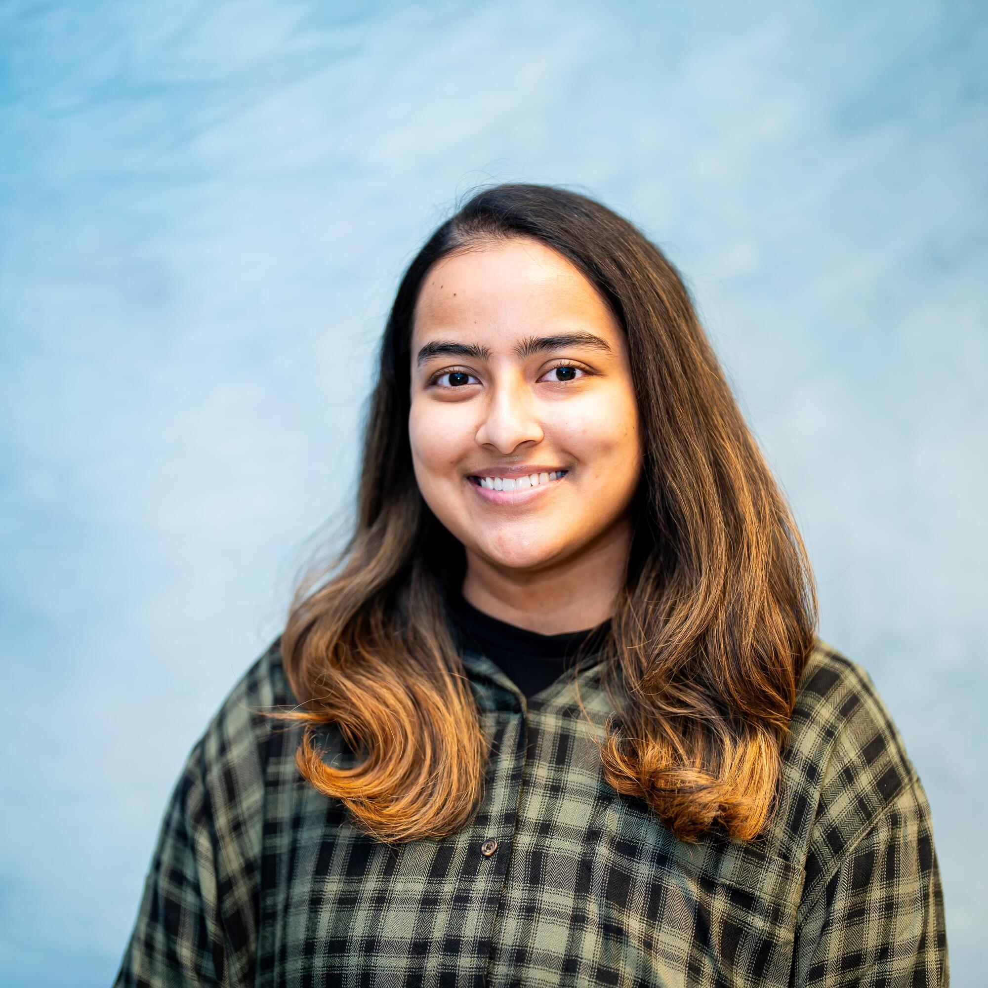 Portrait of student smiling in plaid shirt