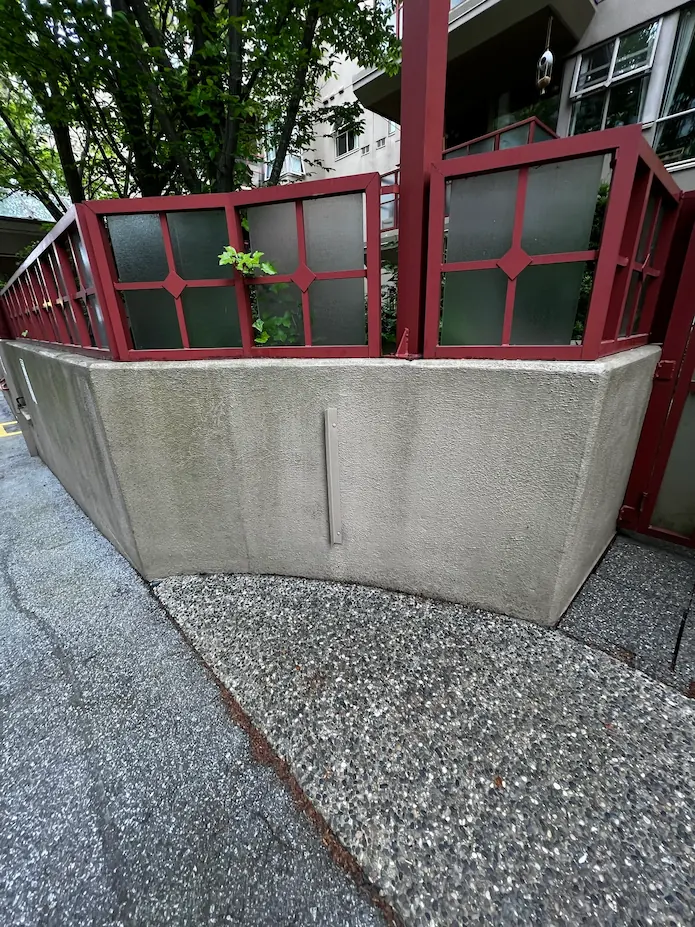 Dirty residential stucco wall with grime and dark stains before professional soft washing service.