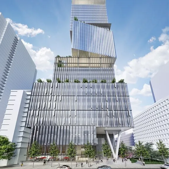 Modern glass skyscraper with staggered, angular sections and rooftop greenery, surrounded by trees and people on the street under a blue sky.