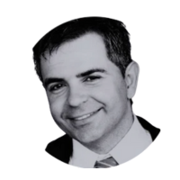 Black and white headshot of a smiling man wearing a suit and tie.