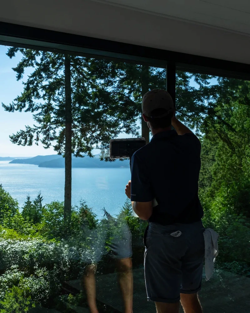 Window cleaning for real estate listings Vancouver showing a technician cleaning large glass windows to improve natural light and listing photo appeal.