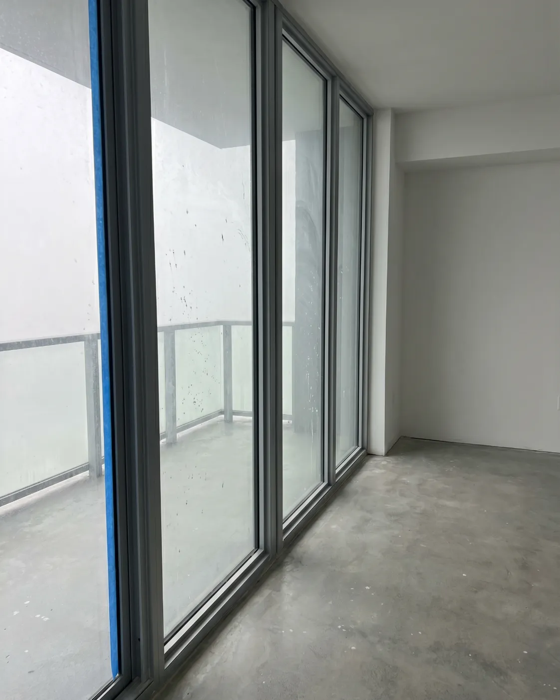 Post construction window cleaning in a Vancouver new build, dust and paint on the glass before cleaning