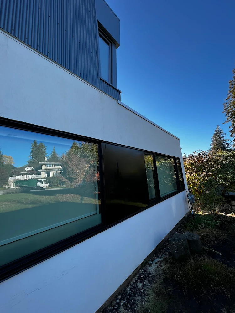 Modern residential home exterior with stucco siding and windows prepared for soft washing service to remove dirt and stains.