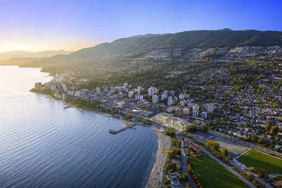 Aerial view of West Vancouver coastline and mountains at sunset - trusted exterior, window, roof, and gutter cleaning experts.