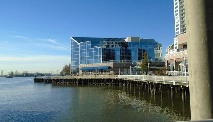 Modern glass buildings along the Fraser River at Quayside, New Westminster; expert window and exterior cleaning services.