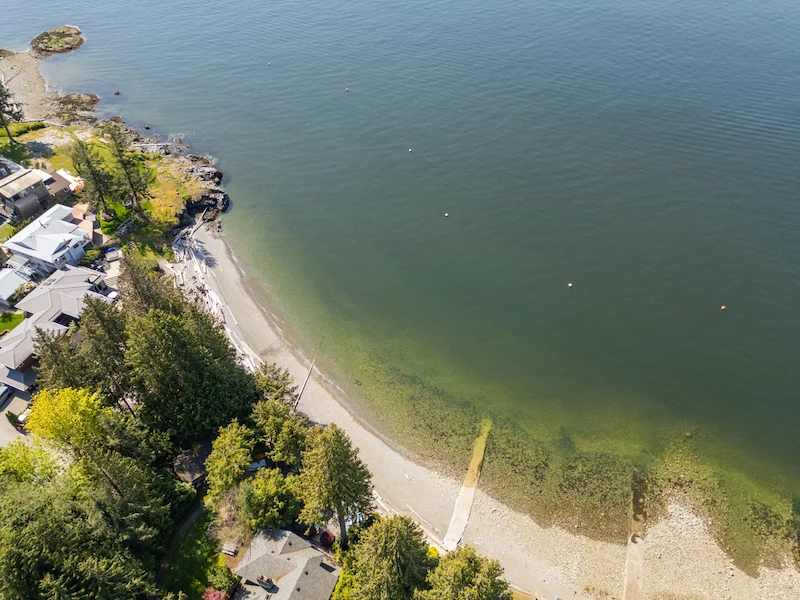 Aerial view of Brunswick Beach homes along the coastline in Lion’s Bay; reliable soft wash and exterior cleaning services.