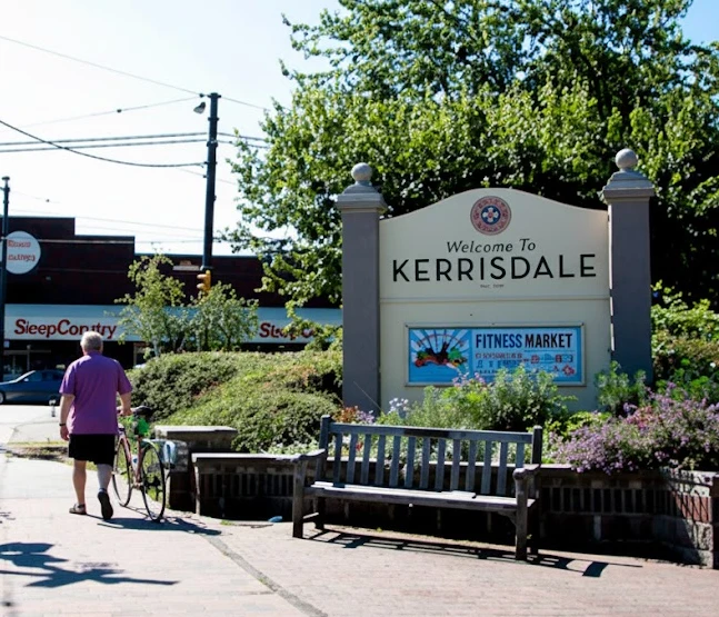 Welcome to Kerrisdale sign with trees and shops in the background; trusted local exterior, window, and roof cleaning experts.