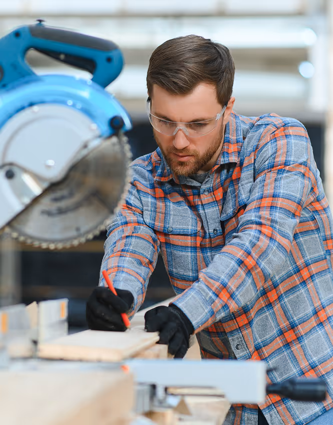 A man sawing through lumber