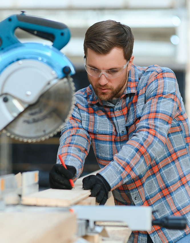 A man sawing through lumber
