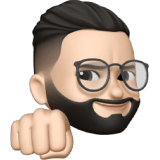 A man with glasses and a beard pointing at the camera.