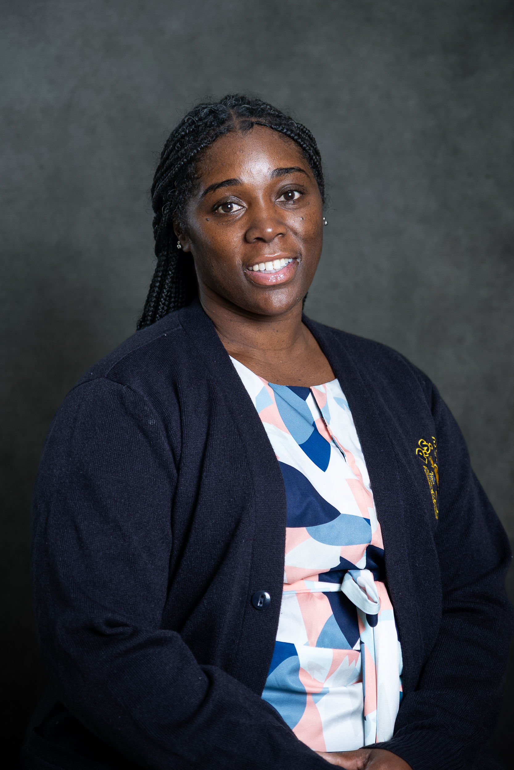 Teacher wearing navy cardigan professional headshot