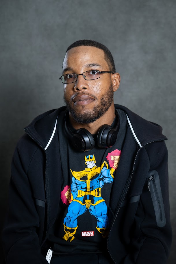 Staff member wearing glasses and headphones in professional portrait