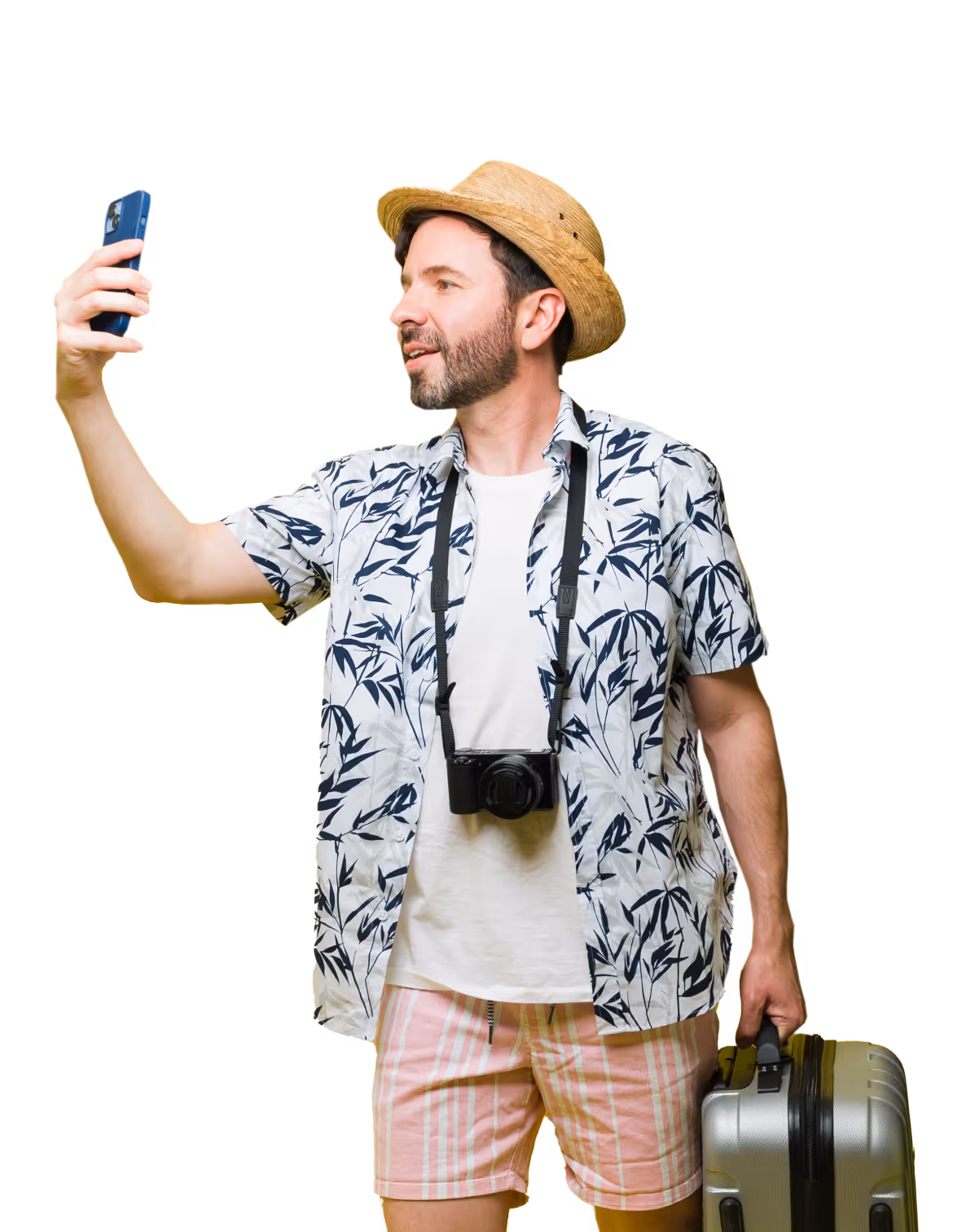 A person wearing a straw hat, tropical shirt, and shorts takes a selfie while holding a suitcase and a camera around their neck.
