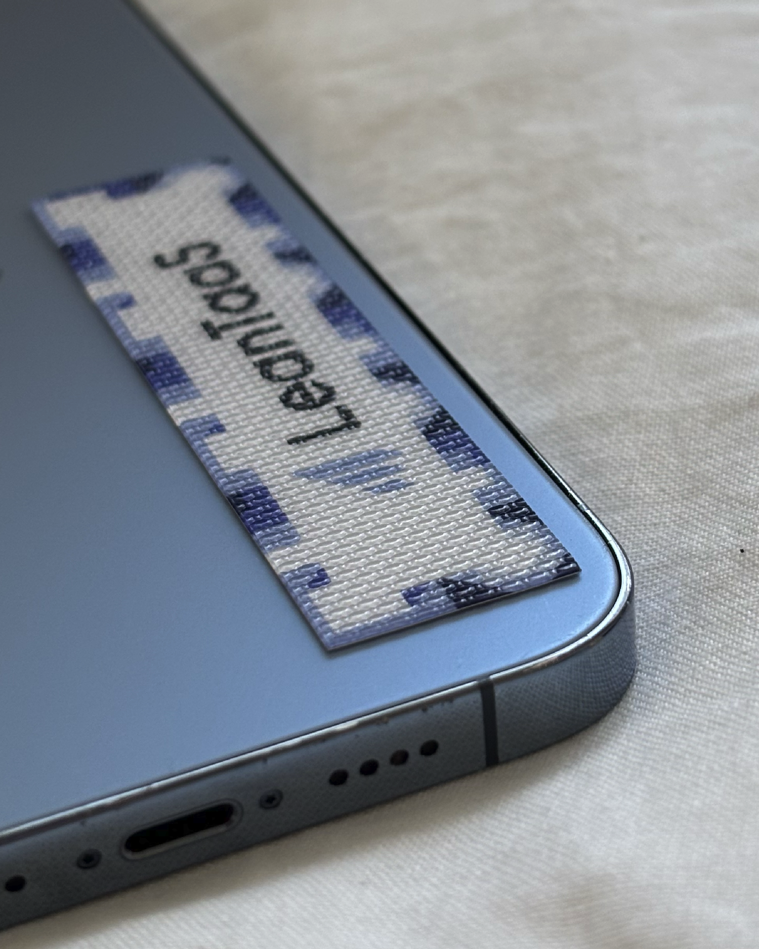 Close up of backside of blue iPhone with LeanTaaS calm strip
