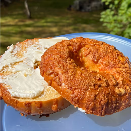 Cream cheese spread on a cheddar bagel