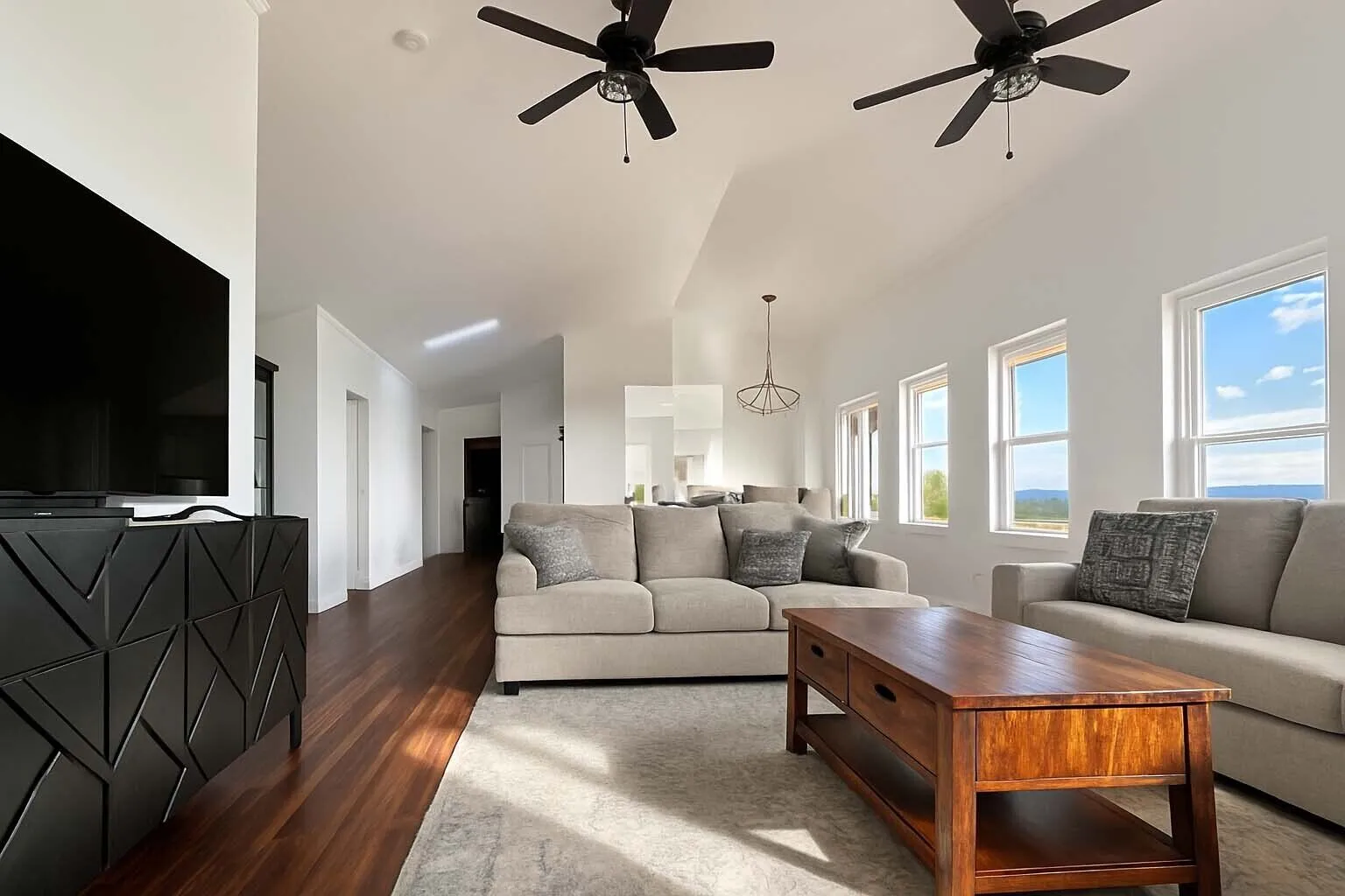 Open living room with sectional sofa and ceiling fans