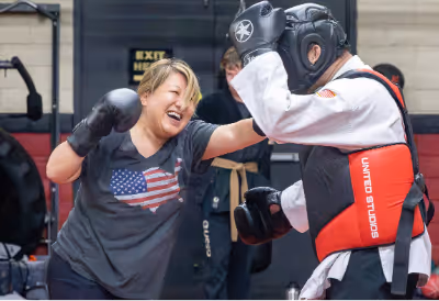 Woman in t-shirt participating in Self Defense Class.