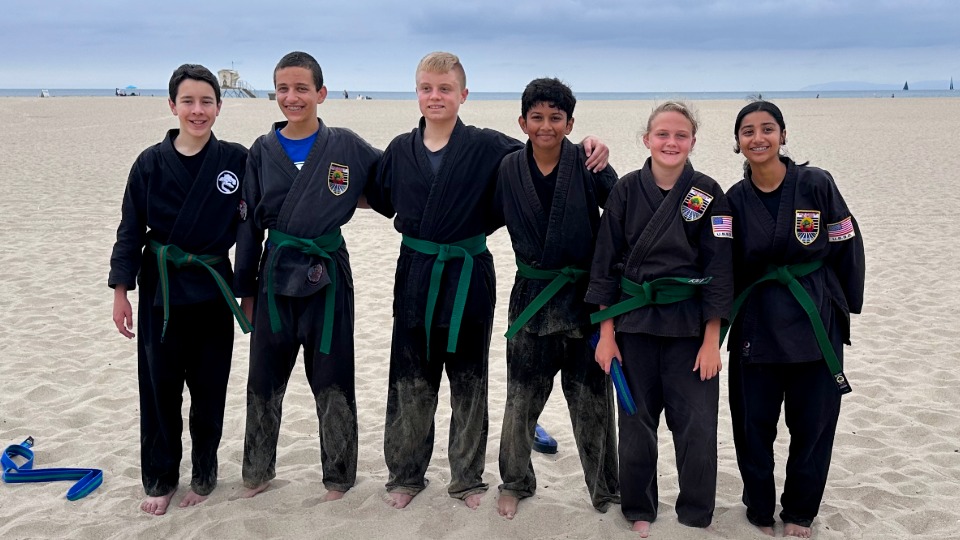 A group of students and instructors posing after the completion of a rank test.