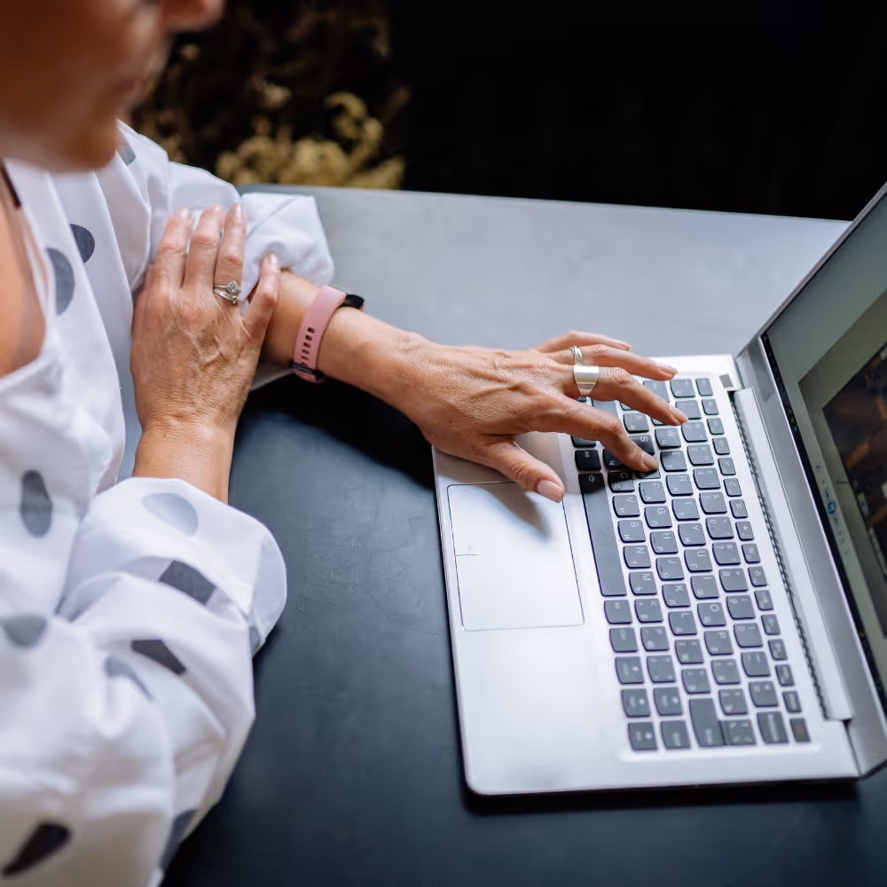 Older woman with a medical wristband searching online for private surgical solutions